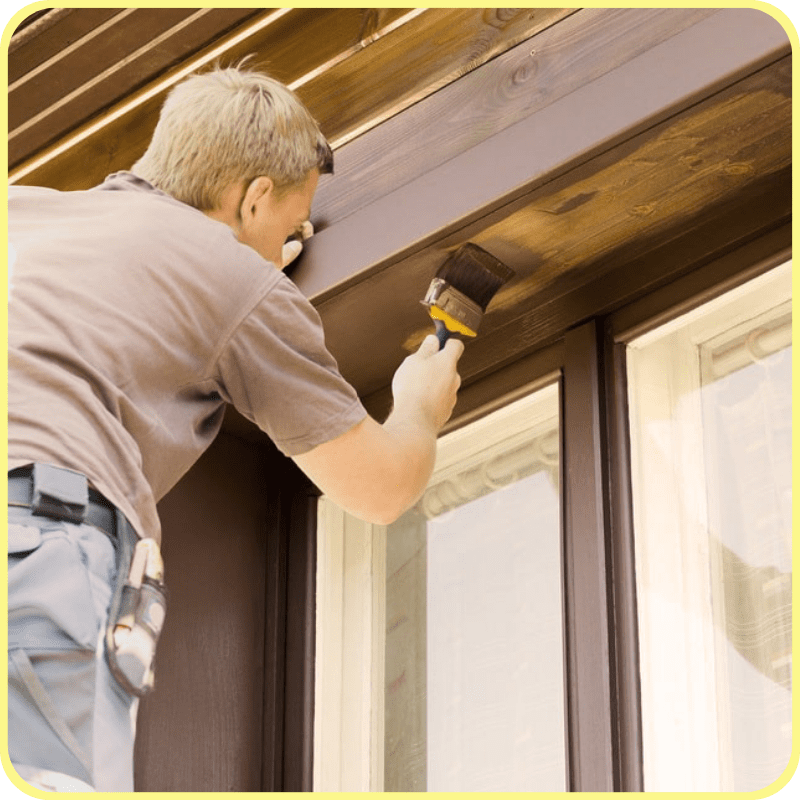 home owner staining the exterior window trim of his home